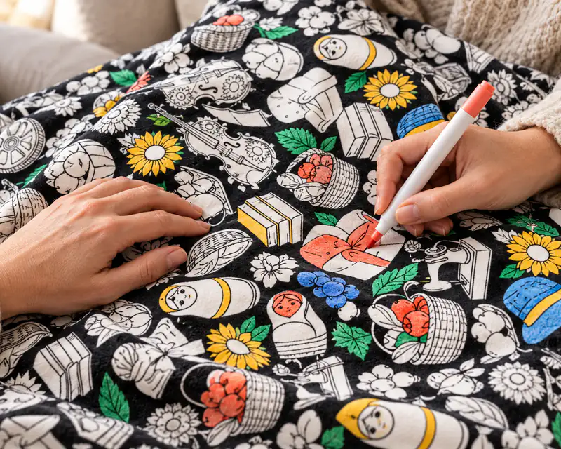 A hand coloring part of the blanket with a fabric marker